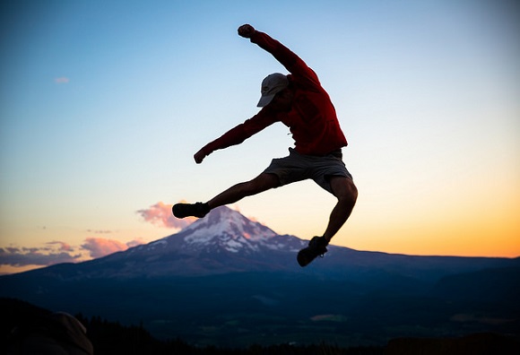 Jumping traveler with mountain backdrop